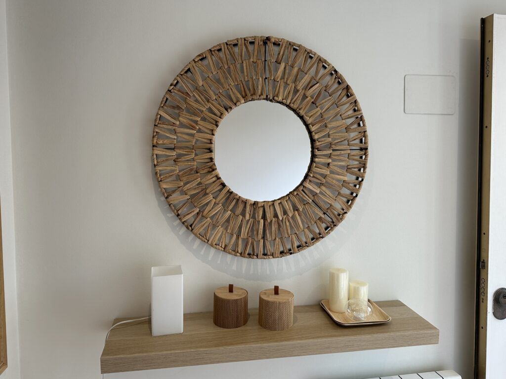 Espejo decorativo redondo de madera sobre balda con velas