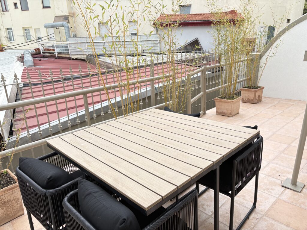 Terraza con mesa plegable, sillones y vistas a los tejados