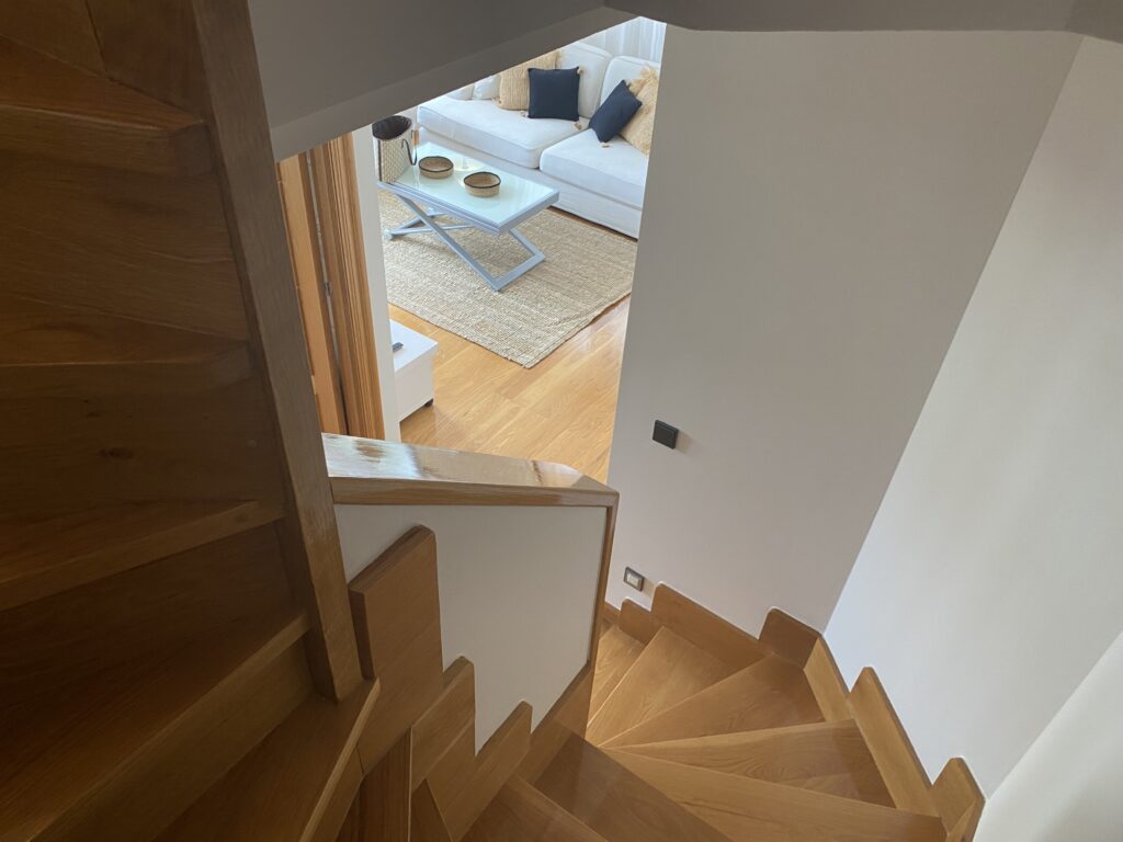 Escalera de madera con vistas al salón desde la planta superior