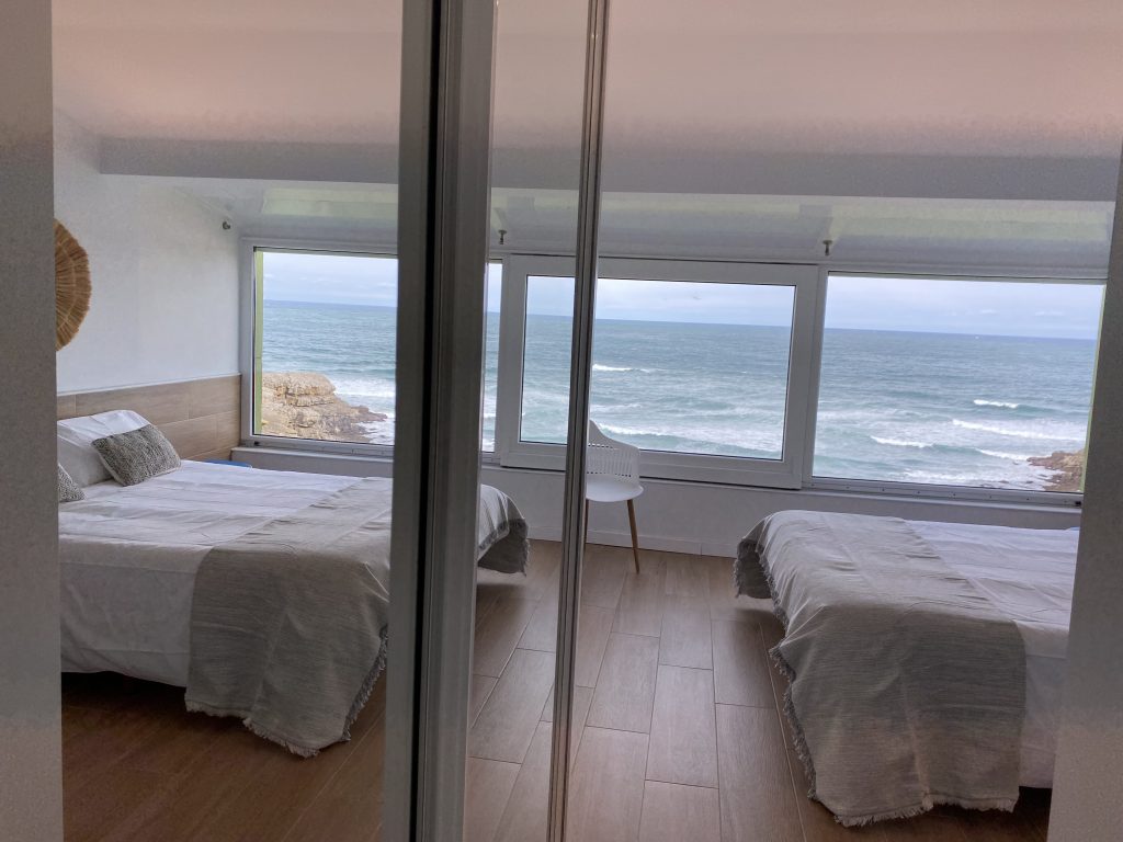 Dormitorio con dos camas individuales y vistas frontales al mar